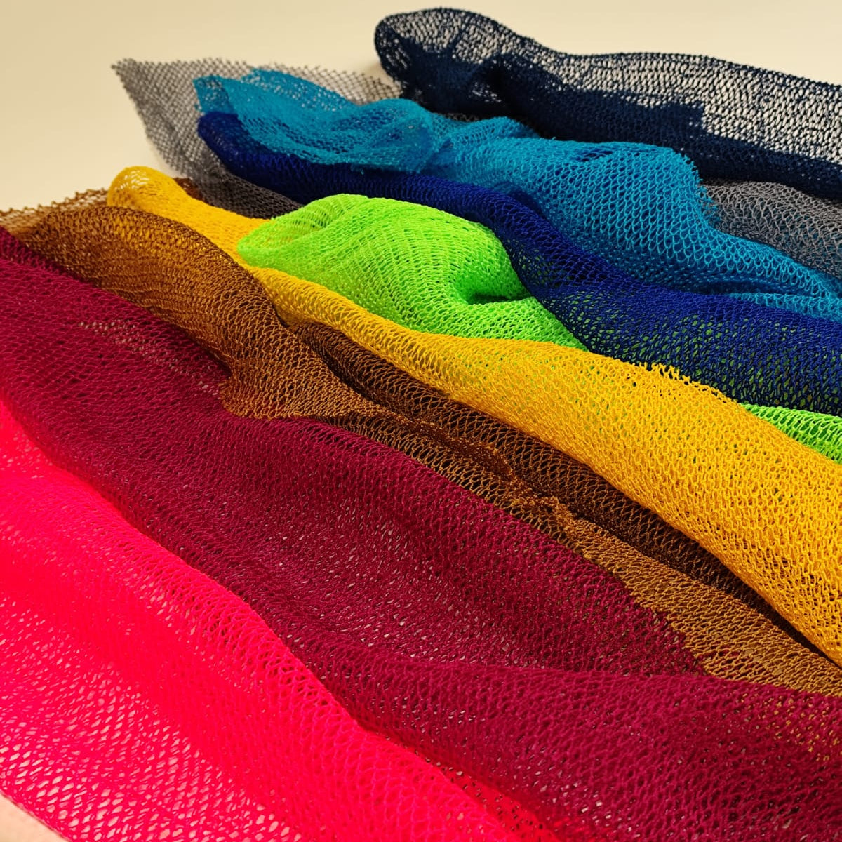 Colorful Inkuto mesh exfoliating sponge set laying on a surface.